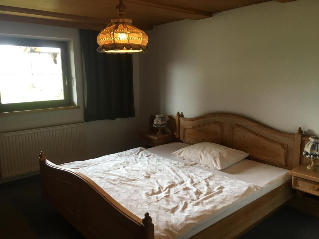 a bed in a bedroom with a chandelier at Appartement Oberlacken in Sankt Johann in Tirol