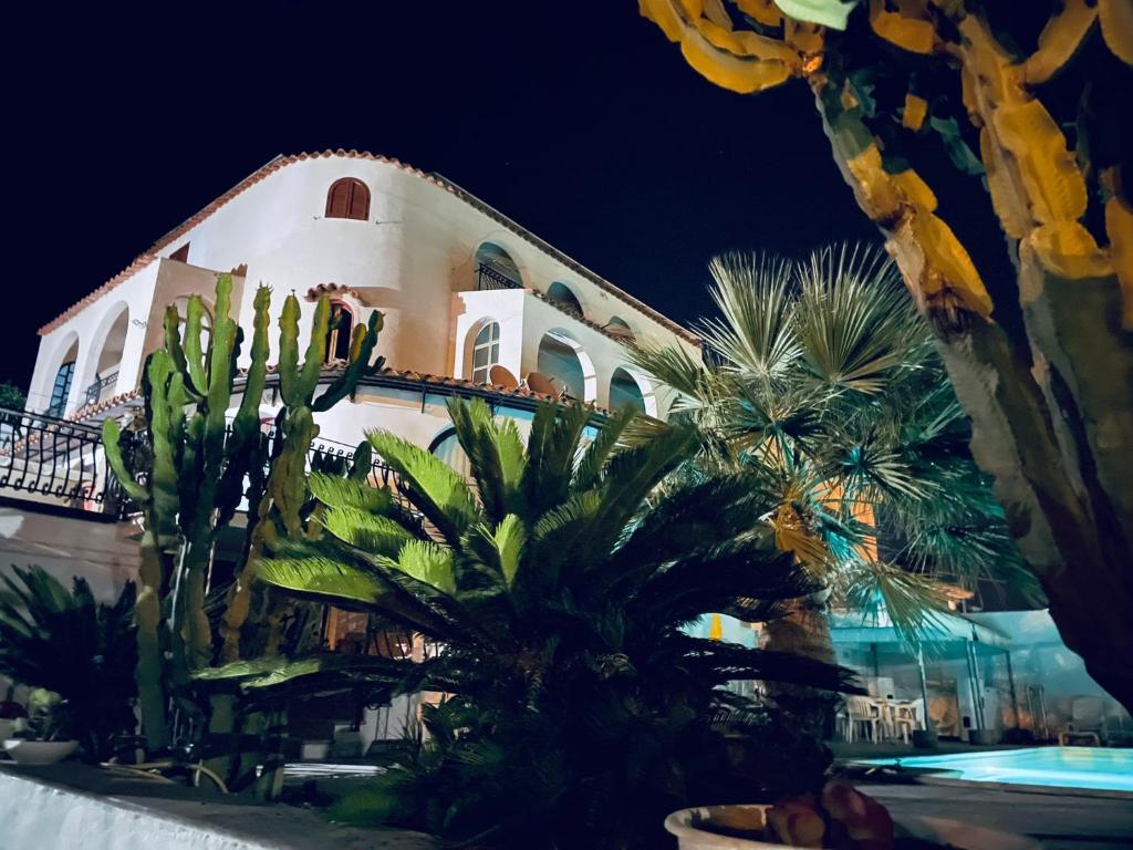 ein großes weißes Gebäude mit Palmen davor in der Unterkunft Manca Residence in Marina di Palma
