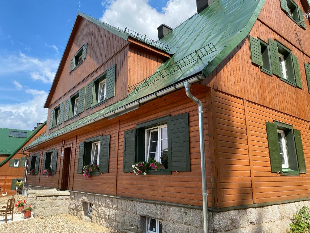 a wooden house with windows and a roof at Chybotek Premium in Przesieka