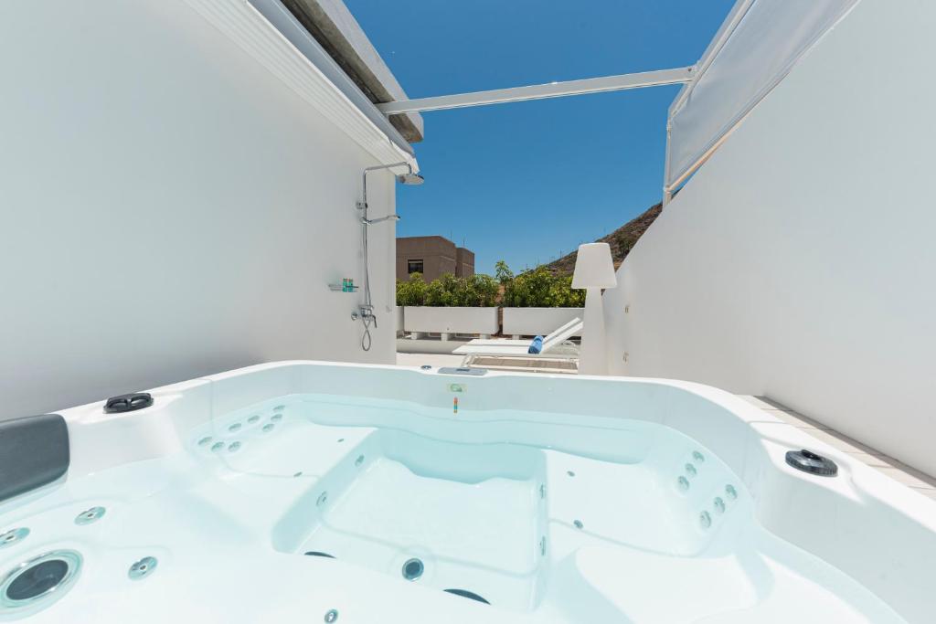 eine weiße Badewanne in einem Zimmer mit Fenster in der Unterkunft The Terraces Luxury Penthouses, 3D in Santa Cruz de Tenerife
