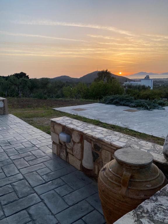 a stone bench with a sunset in the background at Handra Villa in Asfendioú