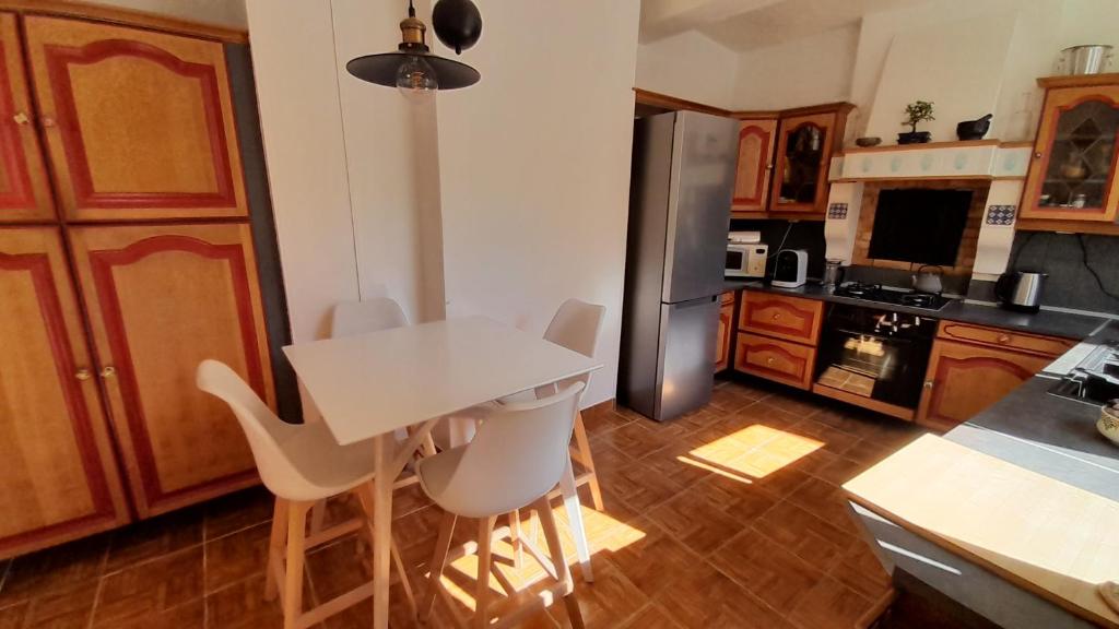 a kitchen with a white table and a refrigerator at Chez Thomas in Sézanne
