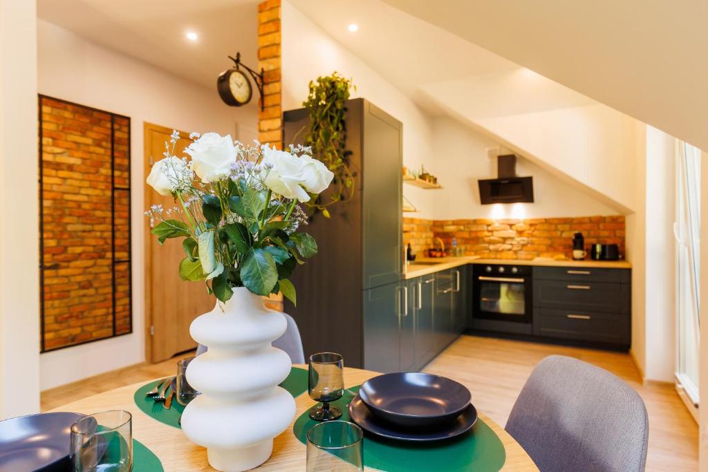 eine Vase mit Blumen auf dem Tisch in der Küche in der Unterkunft Stylowe apartamenty in Charzykowy