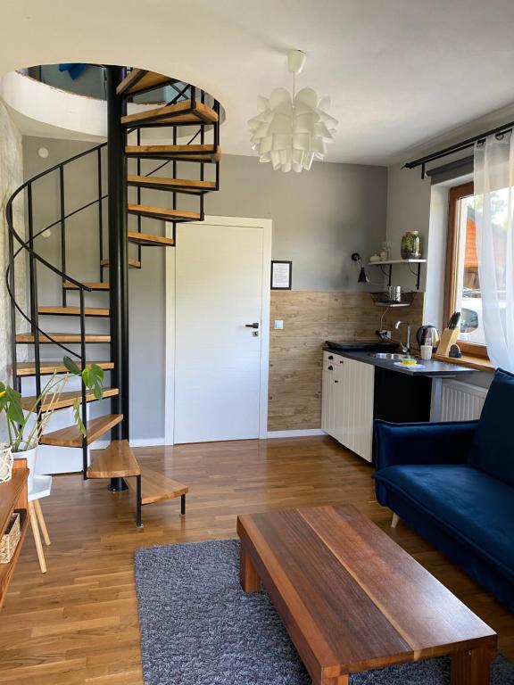 salon z niebieską kanapą i spiralnymi schodami w obiekcie Dom z widokiem w mieście Krynica Zdrój
