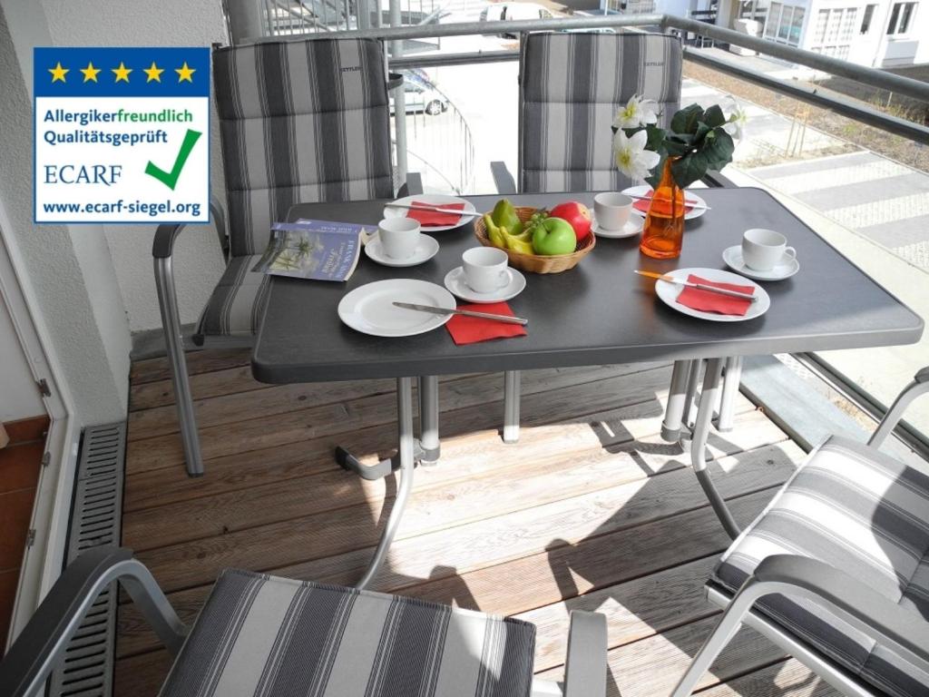 a table with plates of food on a balcony at Möwennest 11 - Großenbrode in Großenbrode
