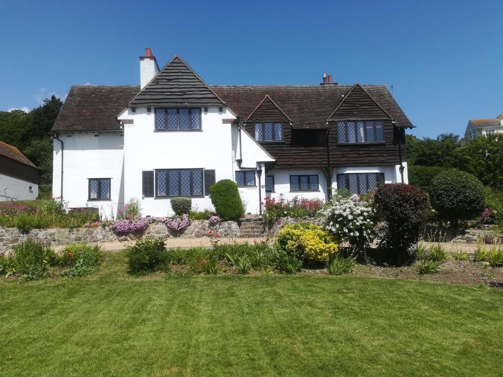 a white house with a garden in front of it at Fern Lodge Guesthouse in Hythe