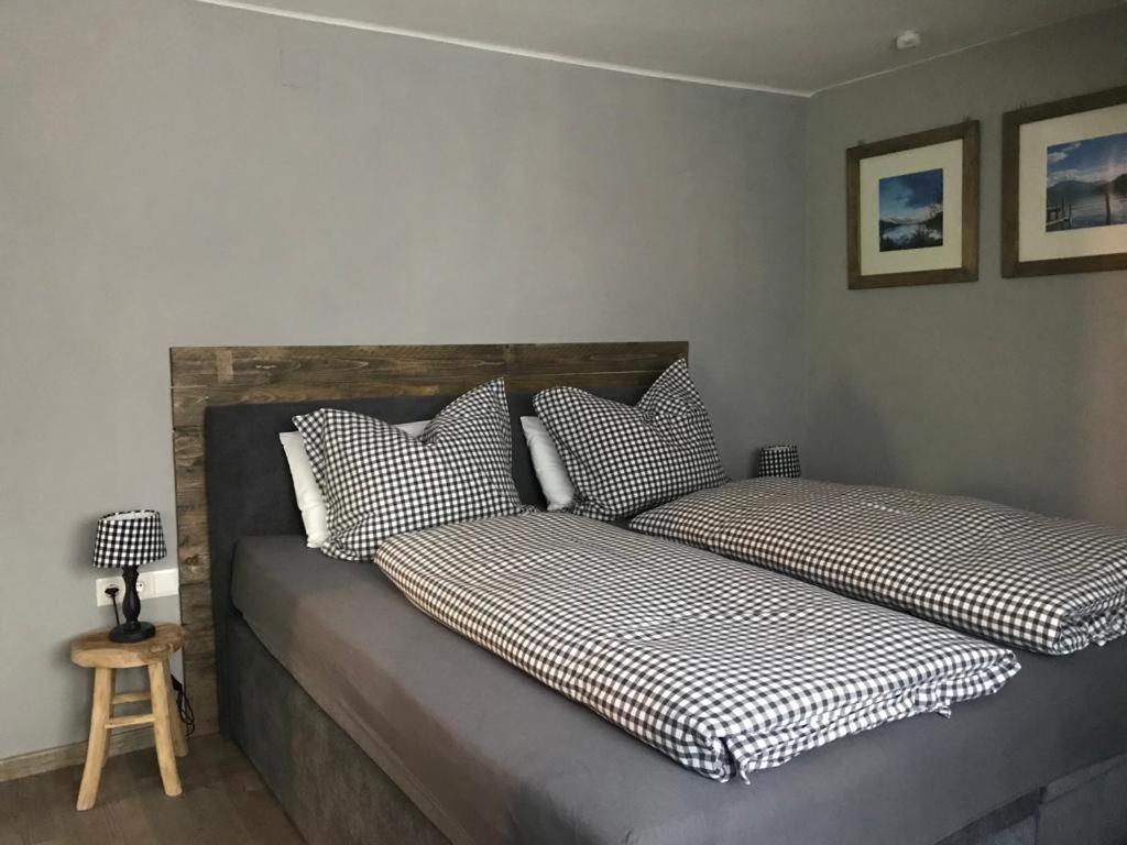 two beds with checkered pillows in a bedroom at Appartement Felsblick Ferienhaus Fuenf Sinne in Döbriach