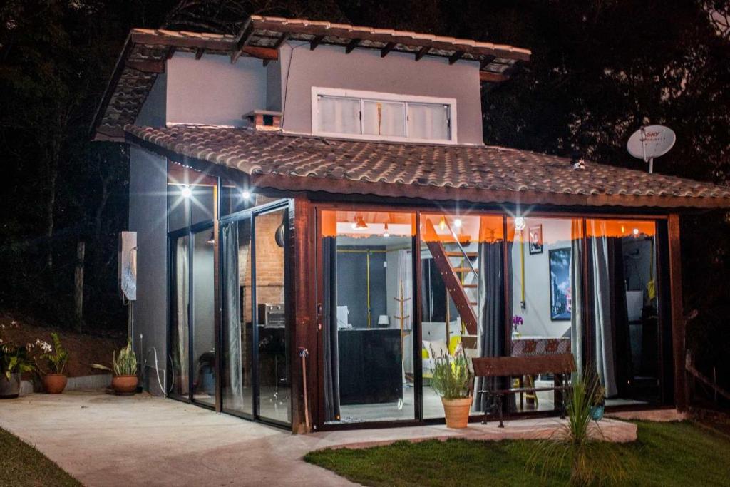 a small house with glass doors in a yard at night at Loft Monte Alegre Village in Monte Alegre do Sul