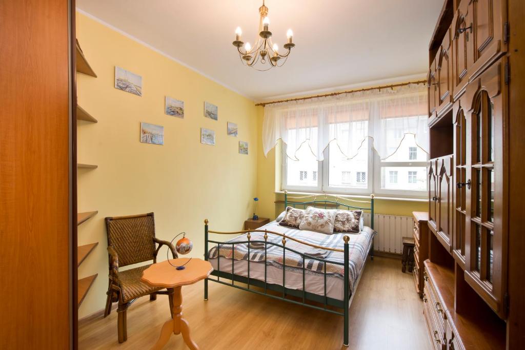 1 dormitorio con 1 cama, 1 silla y 1 mesa en YOURAPART Straganiarska z parkingiem en Gdansk