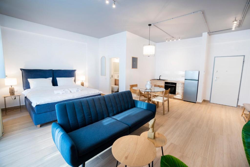 een woonkamer met een bed en een blauwe bank bij Ono Aparthotel in Mamaia Nord – Năvodari