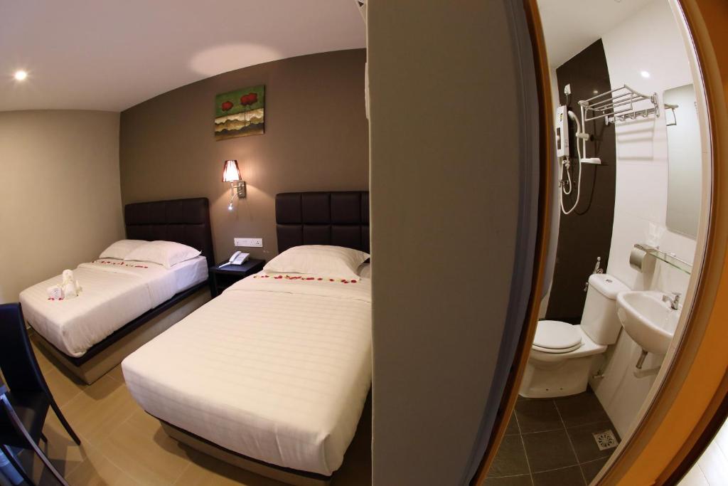 Postel nebo postele na pokoji v ubytování GL Hotel Kluang