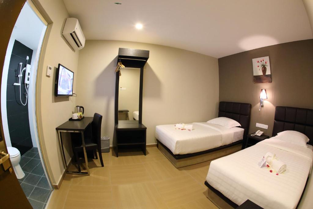 Postel nebo postele na pokoji v ubytování GL Hotel Kluang