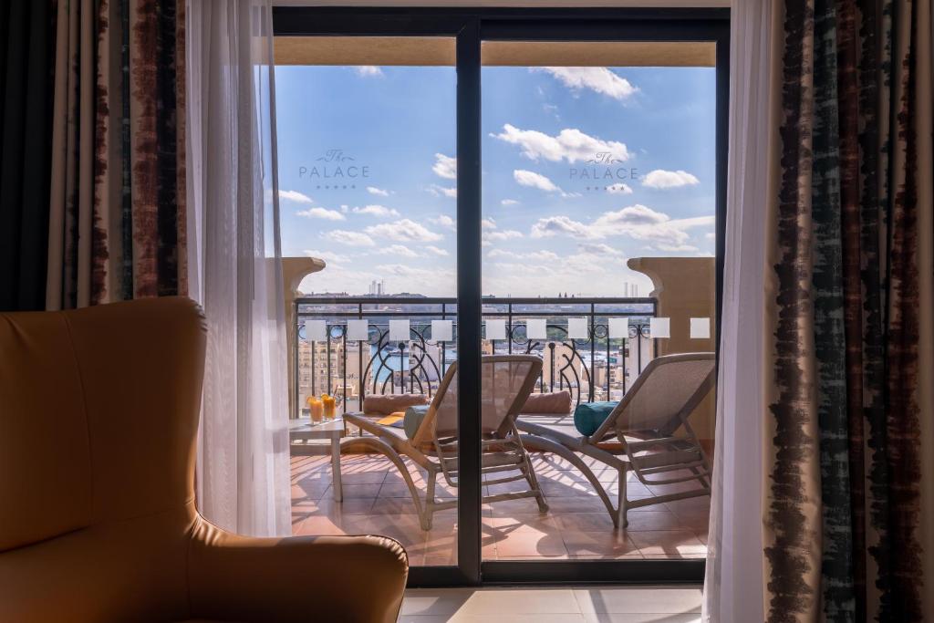 a room with a view of a balcony with chairs at AX The Palace in Sliema