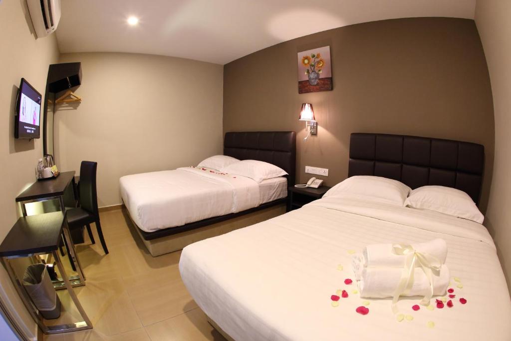 Postel nebo postele na pokoji v ubytování GL Hotel Kluang