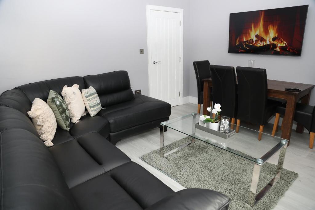 a living room with a black couch and a fireplace at Homely 1-Bed Apartment in Birmingham in Birmingham