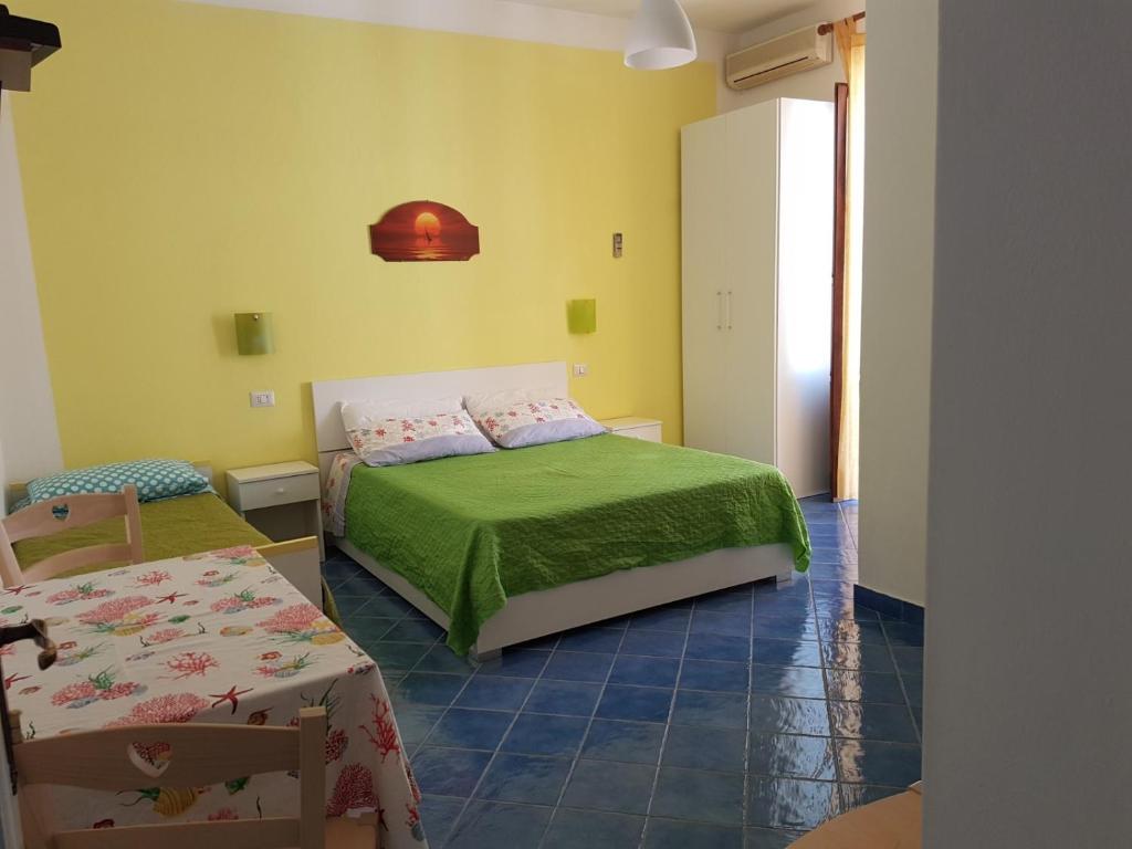 - une chambre avec un lit et une couverture verte dans l'établissement Lipari Centro Storico Flat 7 min from port, à Lipari