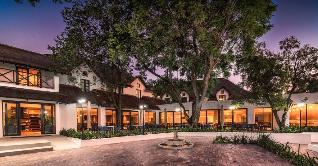 an exterior view of a building with a tree at Indaba Hotel, Spa & Conference Center in Johannesburg