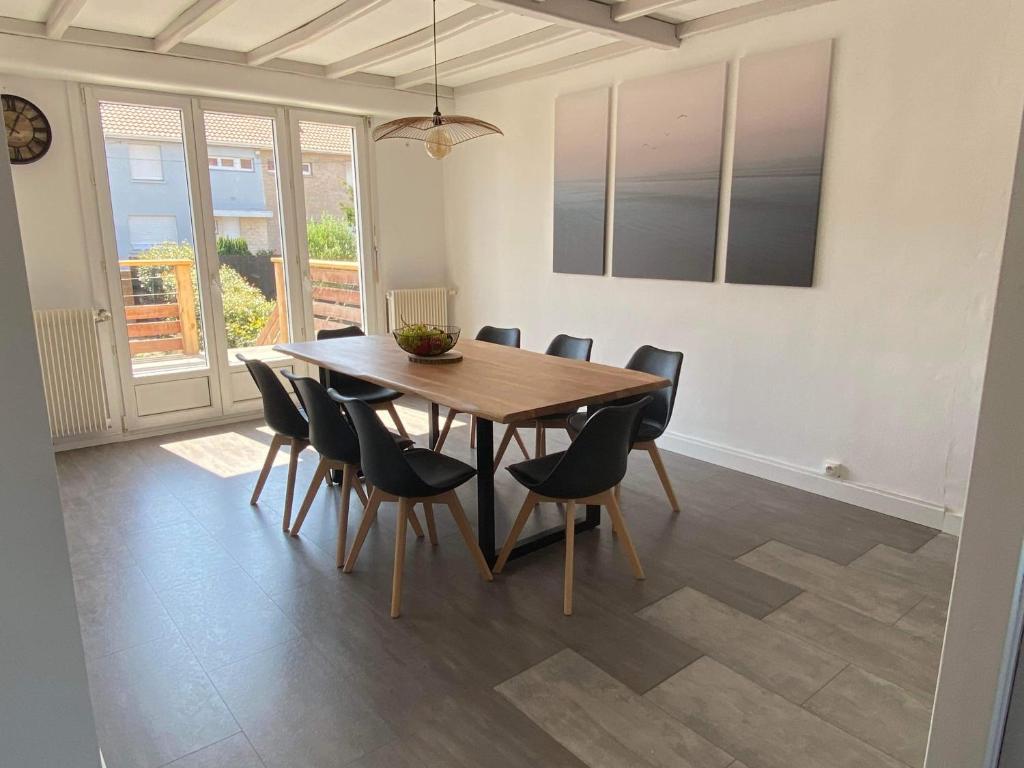 een eetkamer met een houten tafel en stoelen bij L ETOILE DE MALO in Duinkerke