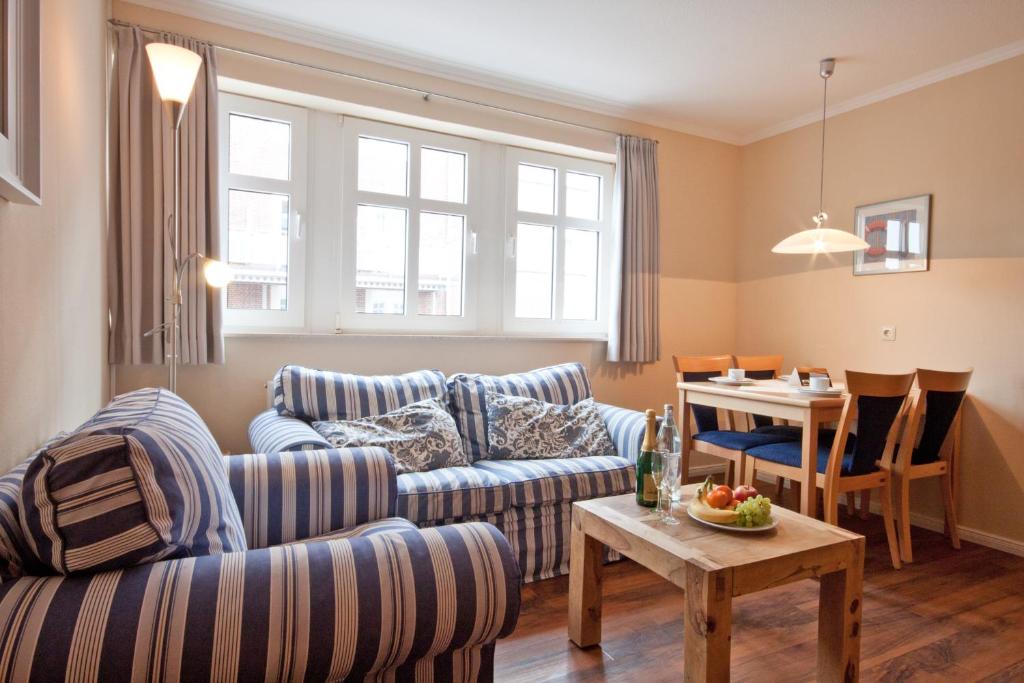 ein Wohnzimmer mit einem Sofa und einem Tisch in der Unterkunft Inselresidenz Strandburg Juist - Wohnung 106 (Ref. 50958) in Juist