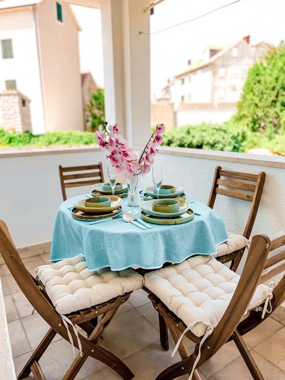 a table with a blue table cloth and chairs on a porch at Central apartments Bol in Bol
