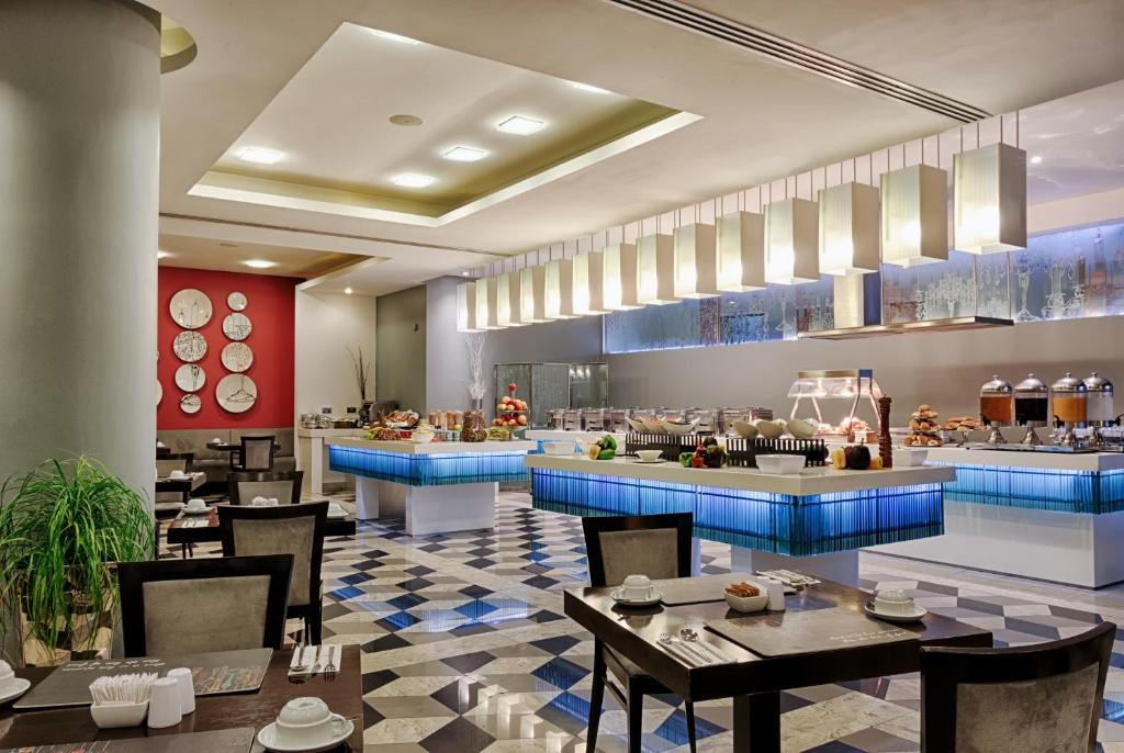 a restaurant with tables and chairs and a kitchen at AX The Palace in Sliema