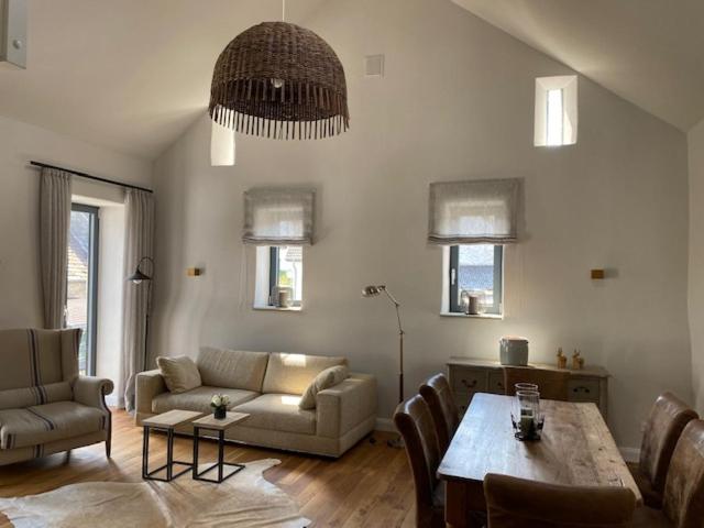 una sala de estar con una mesa y un sofá en Das Alte Bürgermeisteramt, en Kerpen