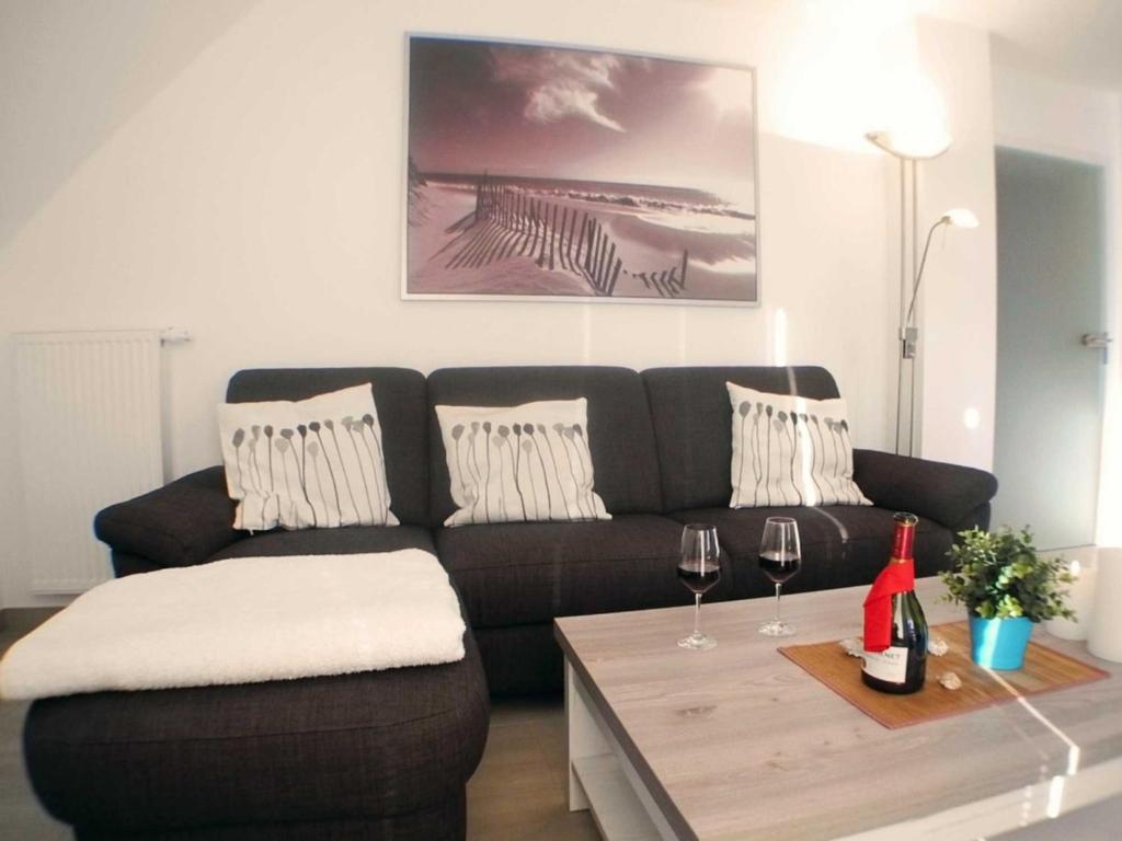 uma sala de estar com um sofá e uma mesa com copos de vinho em Sonnendeck 34 - Großenbrode em Grossenbrode