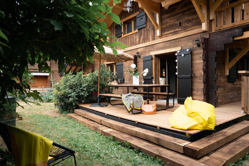 una terraza de madera con mesa y banco en Le Petit Chalet de Montriond, en Montriond