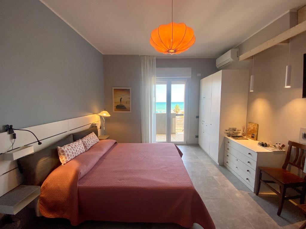1 dormitorio con 1 cama grande con manta naranja en Oltremare Rooms, en Vasto