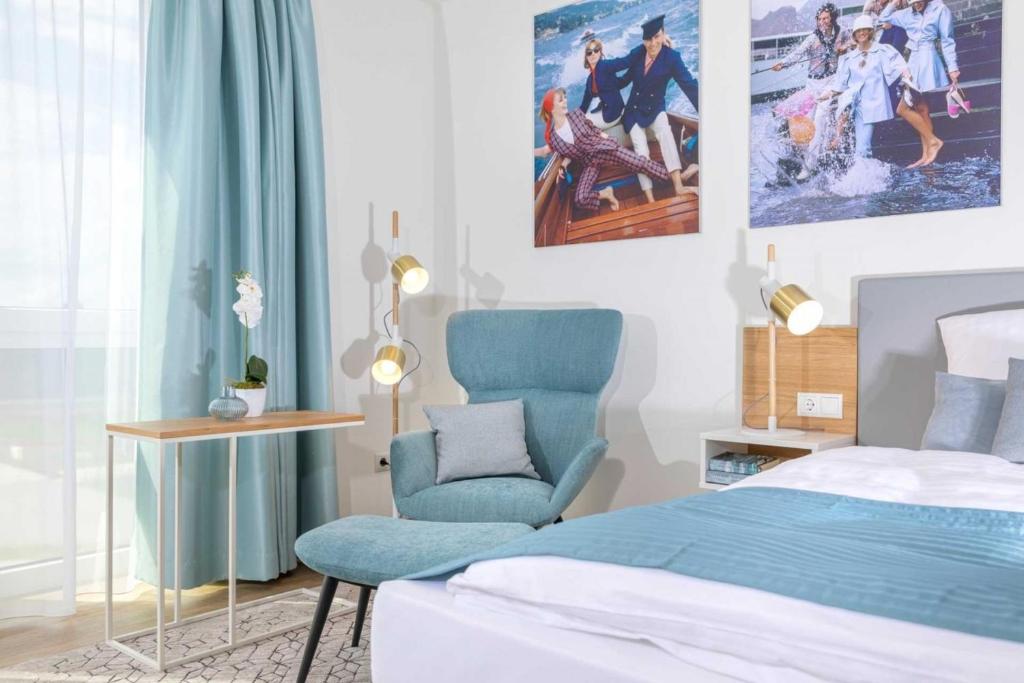 ein Schlafzimmer mit einem Bett und einem blauen Stuhl in der Unterkunft NINO-Boardinghouse 2 - a69884 in Nordhorn