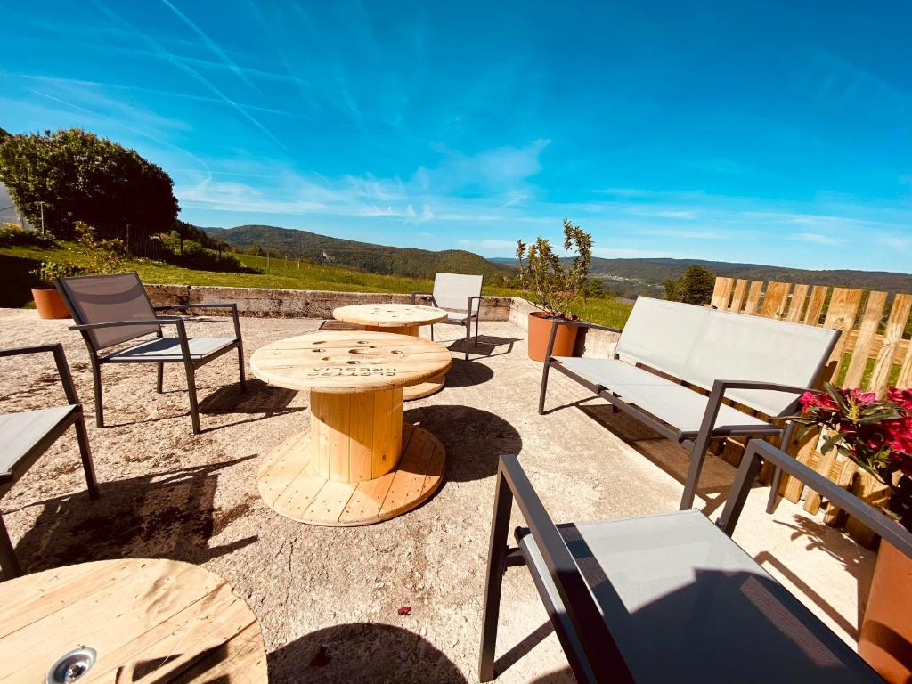 a patio with tables and chairs and a table at Gîte 11 pers - Cadre magnifique in Morbier