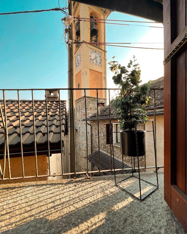a clock tower with a potted plant on a balcony at Residenza Valentino in Locarno