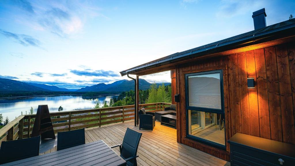 a house with a deck with a view of a lake at Lakeview Vrådal Hyttegrend in Vradal