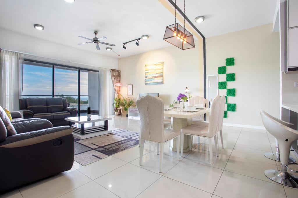 una sala da pranzo e un soggiorno con tavolo e sedie. di AJ Suites @ Loft Imago KK a Kota Kinabalu