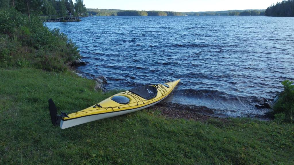 Rämsbyns Fritidsby في Rämshyttan: وجود قوارب الكاياك الصفراء على شاطئ البحيرة