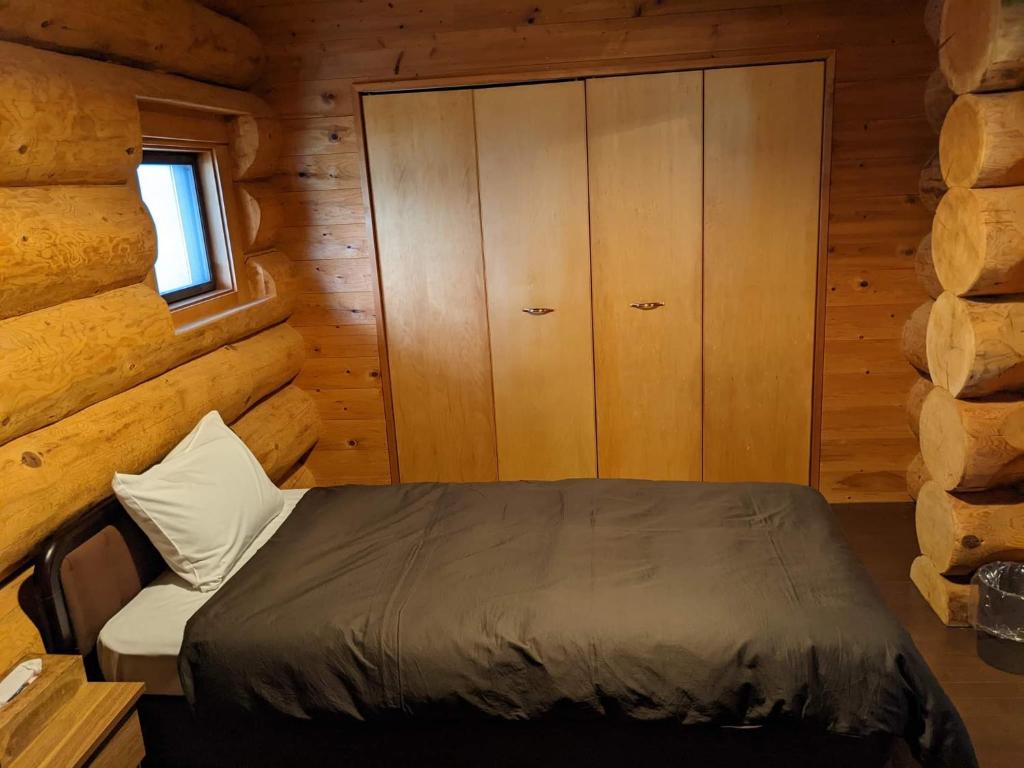 Postel nebo postele na pokoji v ubytování White Tree Log House Madarao Tangram