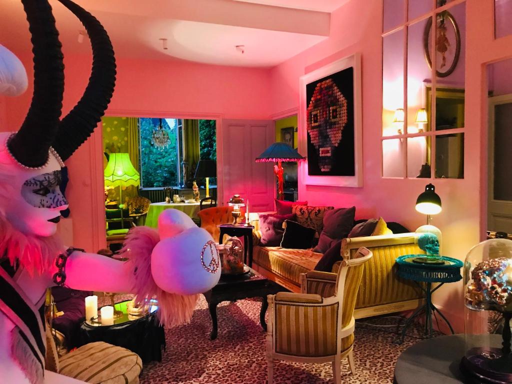 a room with a living room with pink walls at La Maison des Roses in Moulins
