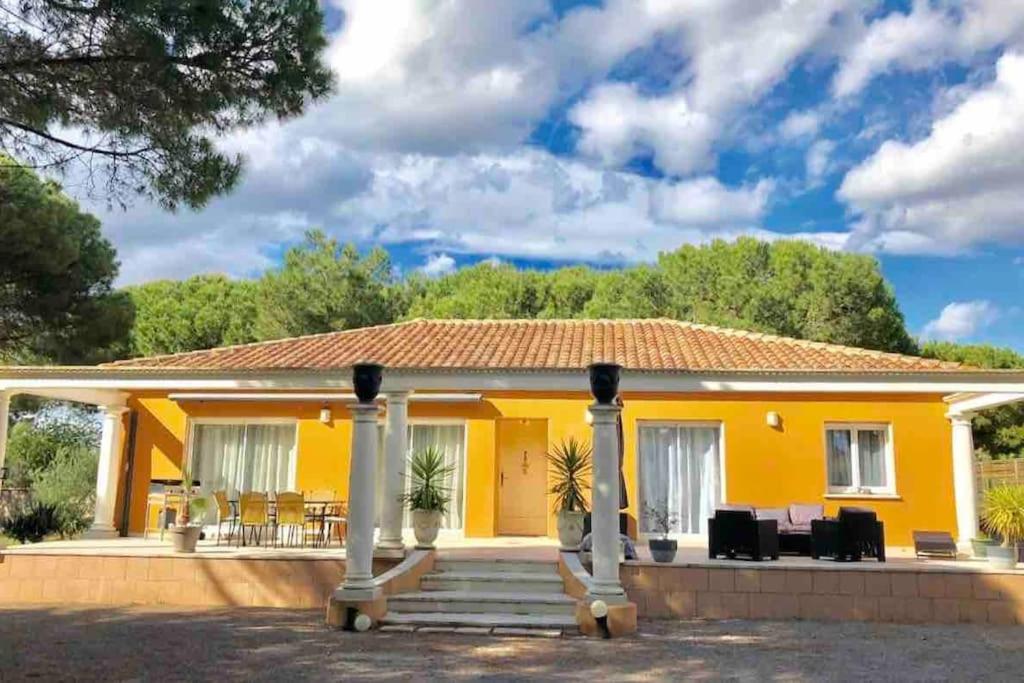 une maison jaune avec une terrasse couverte dans l'établissement Villa des Pins - Jolie villa proche de la plage, au Grau-dʼAgde