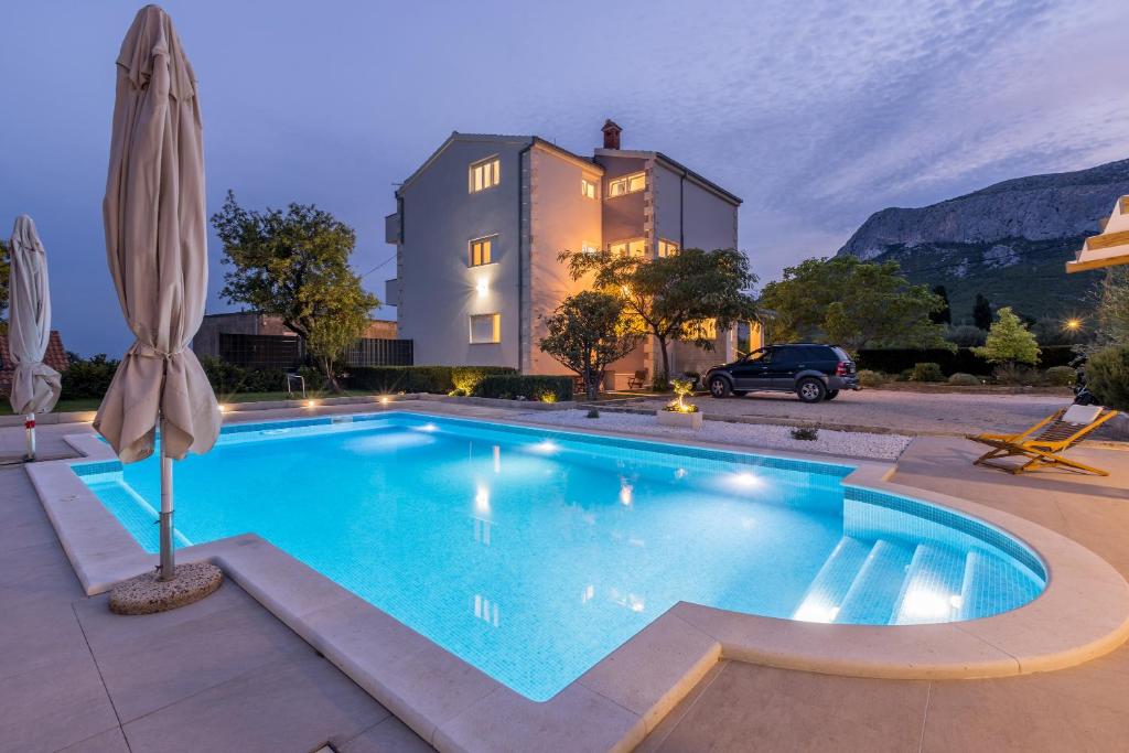 a swimming pool in front of a house at Melki for 12 people with private pool in Klis