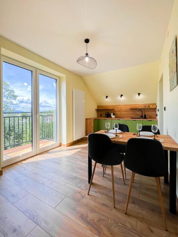a dining room with a table and chairs with a view at Apartament Ptasi Śpiew in Rabka-Zdrój