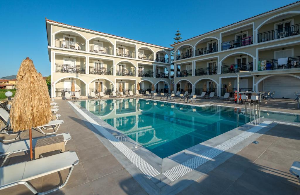 a swimming pool in front of a large building at Athina Apartments in Kalamaki