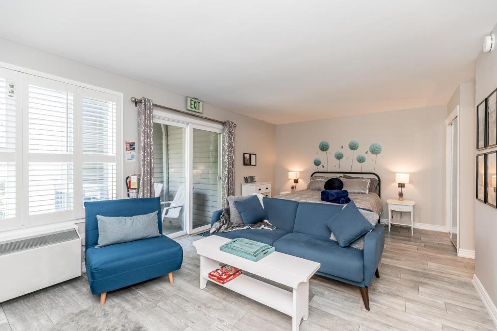 a living room with a blue couch and a bed at Blue Heart Mountain Studio Dream Walk to slopes, tennis in Blue Mountains