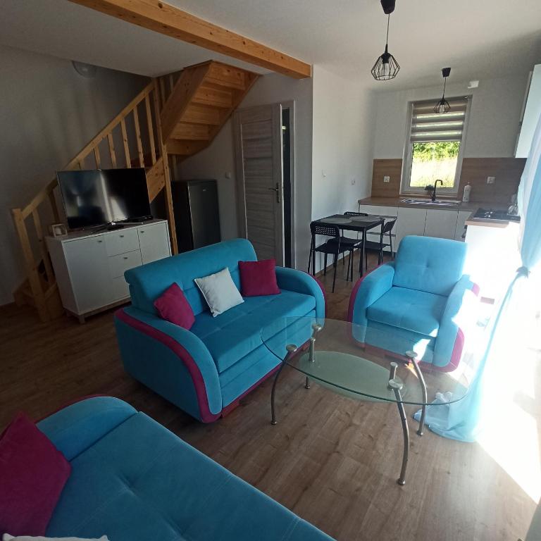 een woonkamer met twee blauwe stoelen en een tafel bij W cieniu Szarloty in Rydułtowy