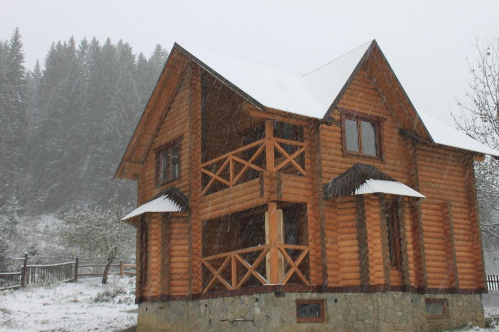 a log cabin in the snow with snow at Sadyba Kazkove Dzherelo in Verkhovyna