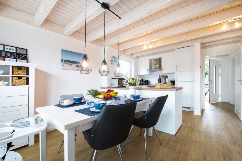 a kitchen and dining room with a white table and chairs at Maritimes Glück - Nordhorn in Nordhorn