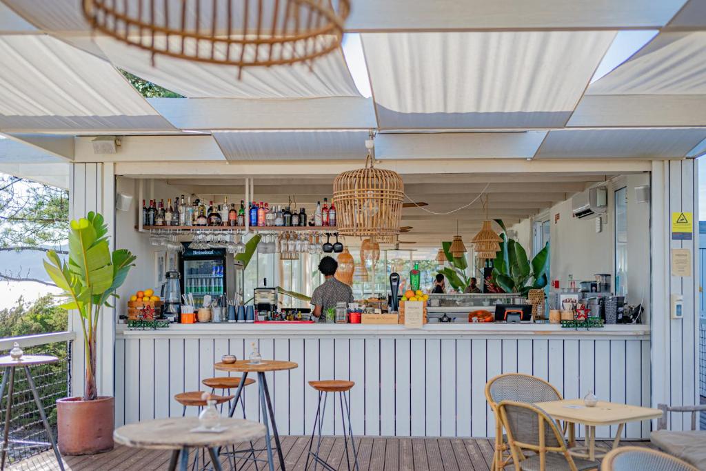 a restaurant with a bar with a person in the kitchen at Pestana Troia Eco-Resort & Residences in Troia