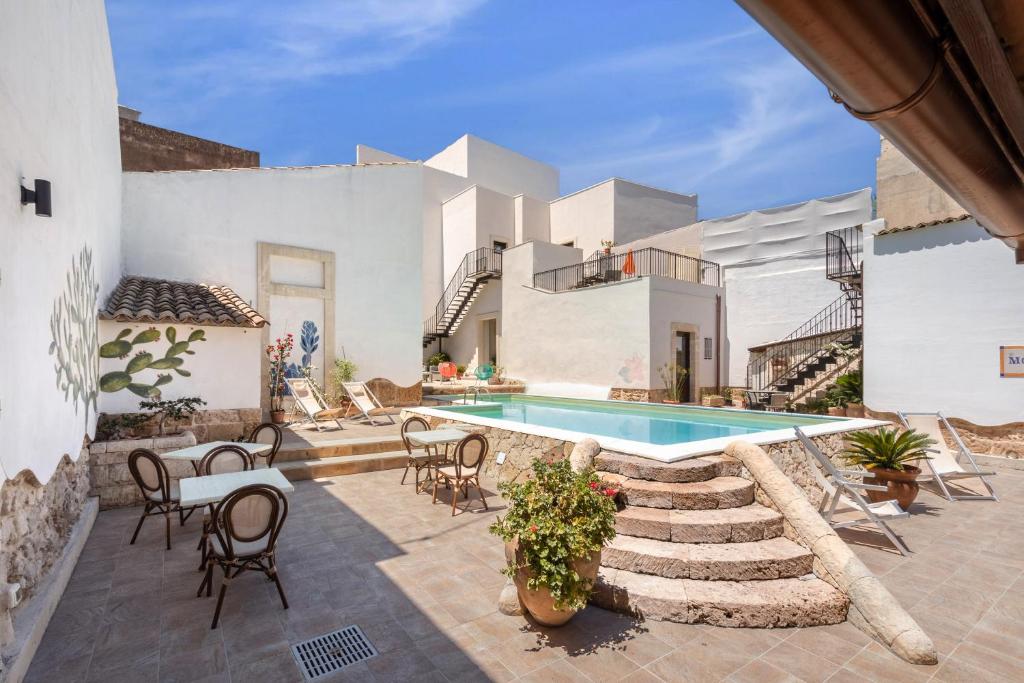 a patio area with a patio table and chairs at Morfeo charming Rooms & relax in Avola