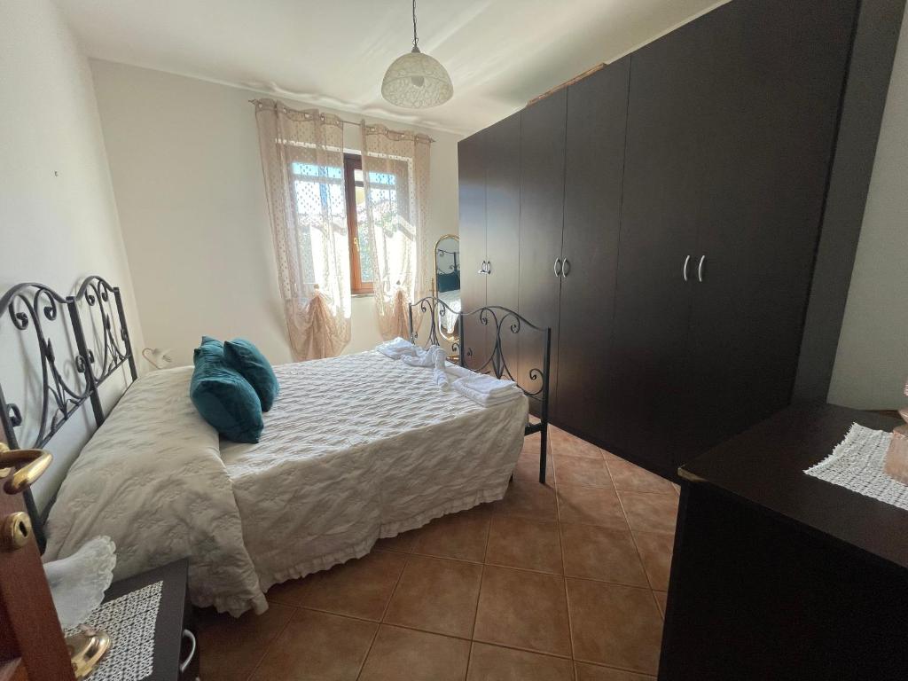 a bedroom with a bed with a blue pillow on it at Alloggio turistico La tartaruga in Capranica