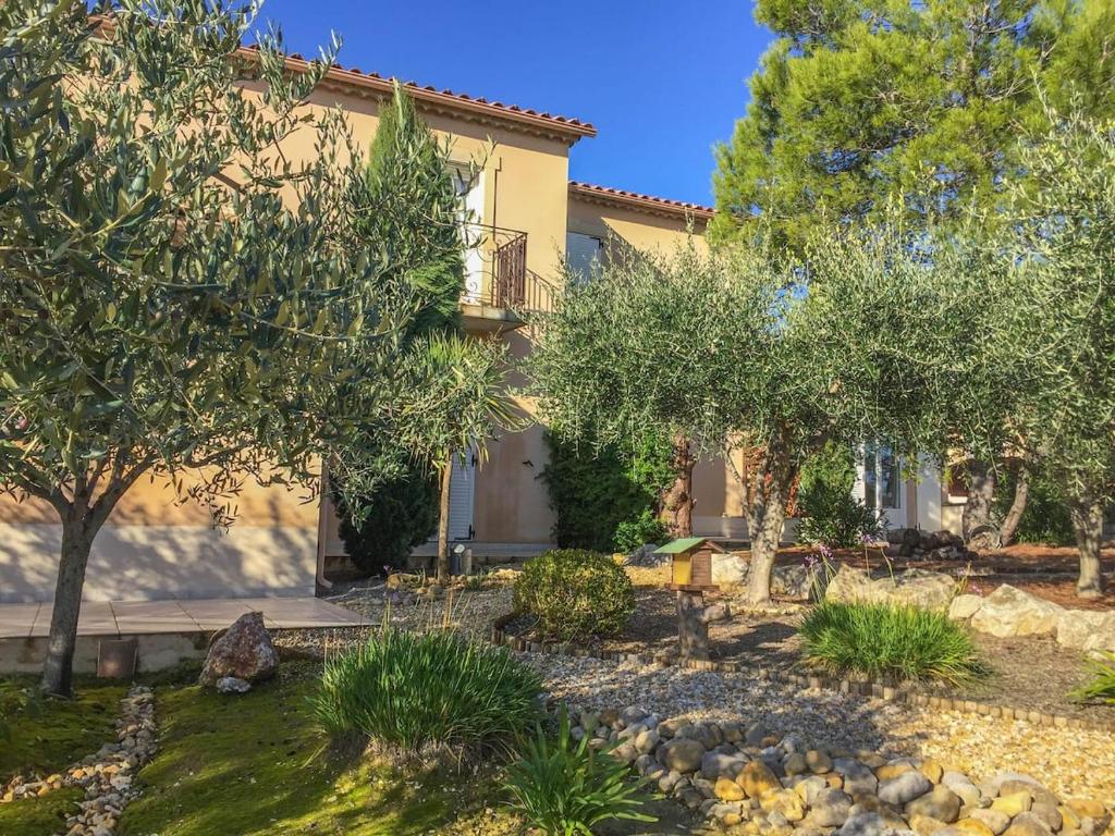 uma casa com um jardim em frente em Anduze Gîte Les Lauriers au "Petit Clos des Cigales" em Massillargues-Attuech