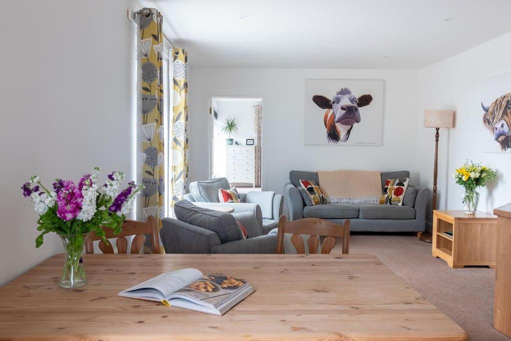 a living room with a table and a couch at The Stables @ Higher Stancombe Farm in Kingsbridge